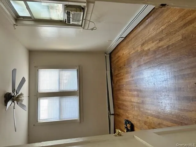 Spare room featuring plenty of natural light, baseboard heating, light wood finished floors, and cooling unit Spare room featuring plenty of natural light, baseboard heating, light wood finished floors, and cooling unit