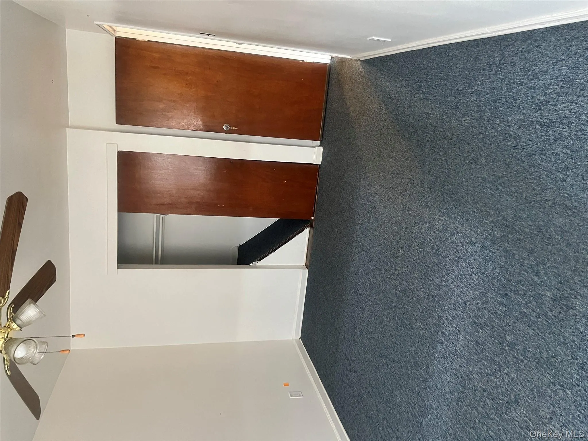 Unfurnished bedroom with a ceiling fan, a closet, and dark carpet Unfurnished bedroom with a ceiling fan, a closet, and dark carpet