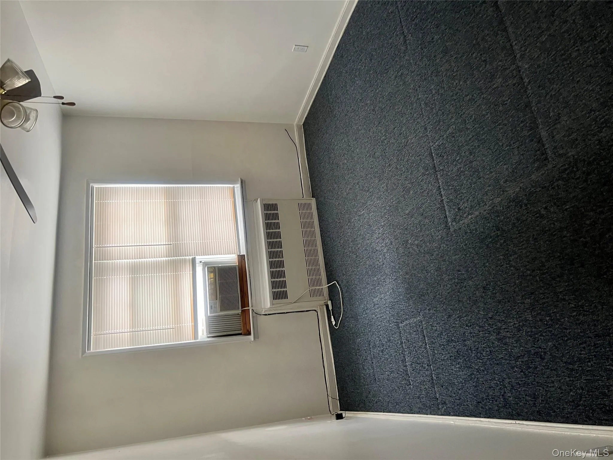 Unfurnished room featuring radiator heating unit, a ceiling fan, and cooling unit Unfurnished room featuring radiator heating unit, a ceiling fan, and cooling unit