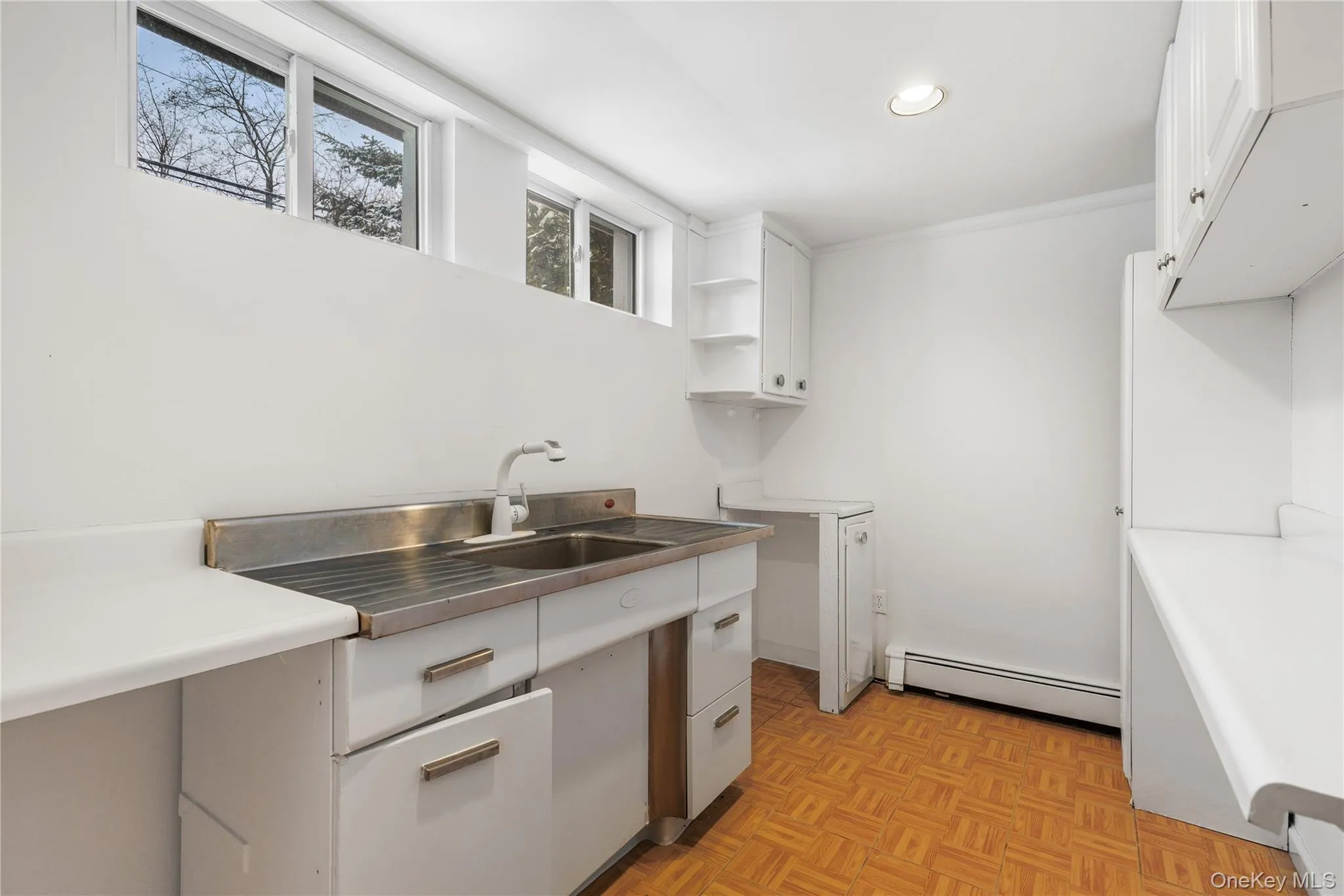 Kitchen with white cabinets, light countertops, and recessed lighting Kitchen with white cabinets, light countertops, and recessed lighting