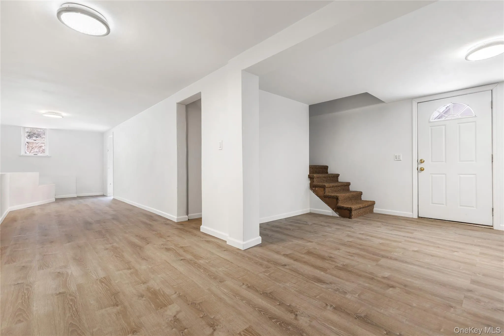 Below grade area featuring light wood-style flooring and stairway Below grade area featuring light wood-style flooring and stairway