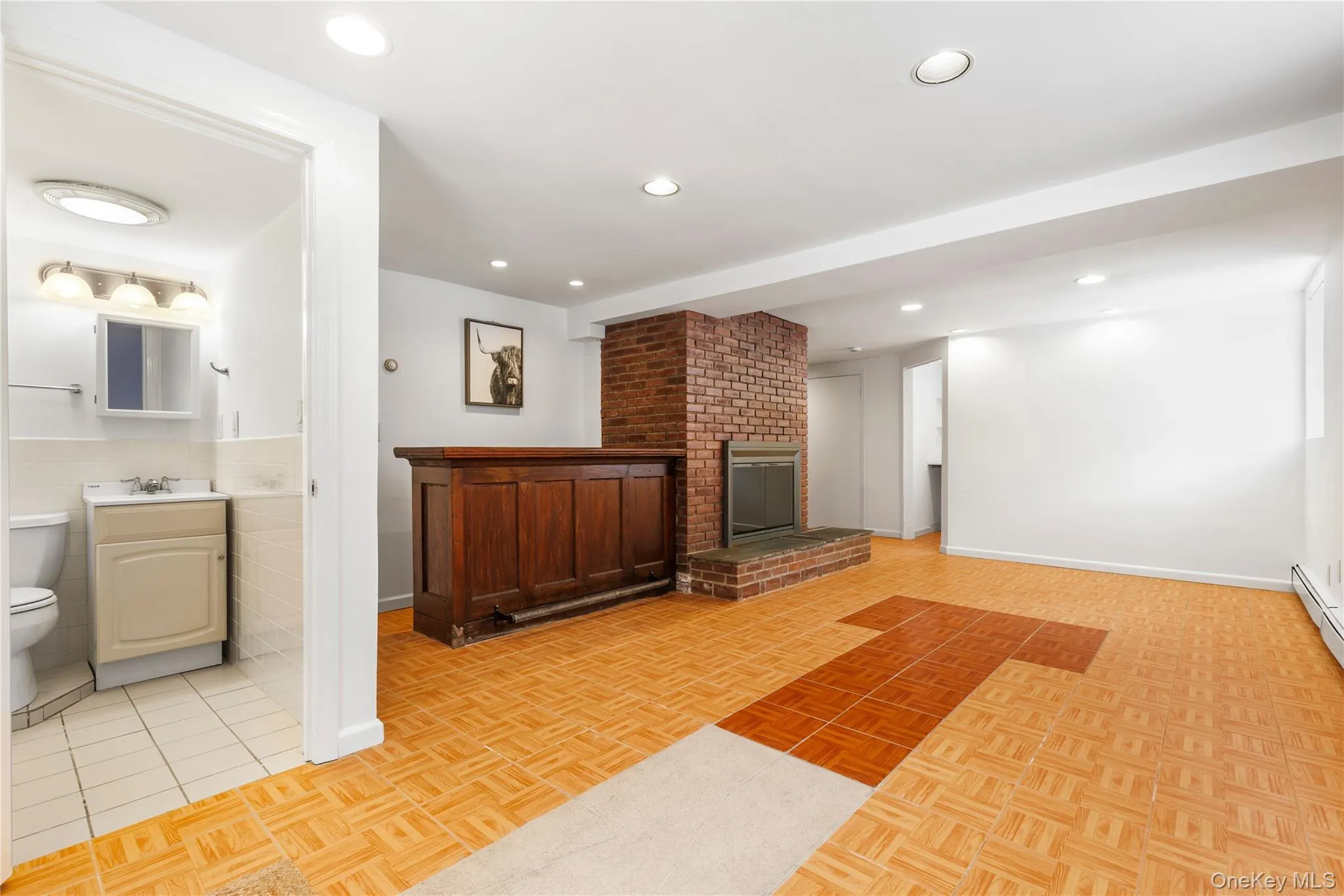 Unfurnished living room with parquet flooring, a brick fireplace, and recessed lighting Unfurnished living room with parquet flooring, a brick fireplace, and recessed lighting