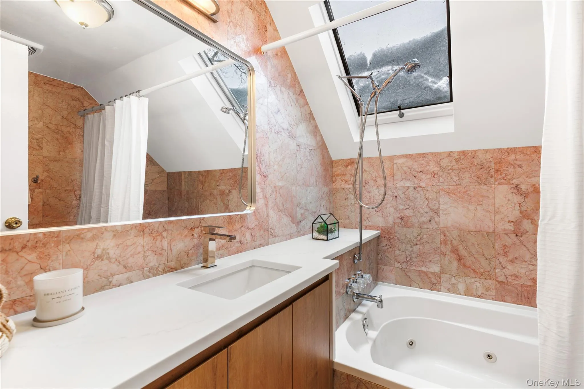 Full bathroom with vanity, a combined bath / shower with jetted tub, tile walls, lofted ceiling, and backsplash Full bathroom with vanity, a combined bath / shower with jetted tub, tile walls, lofted ceiling, and backsplash