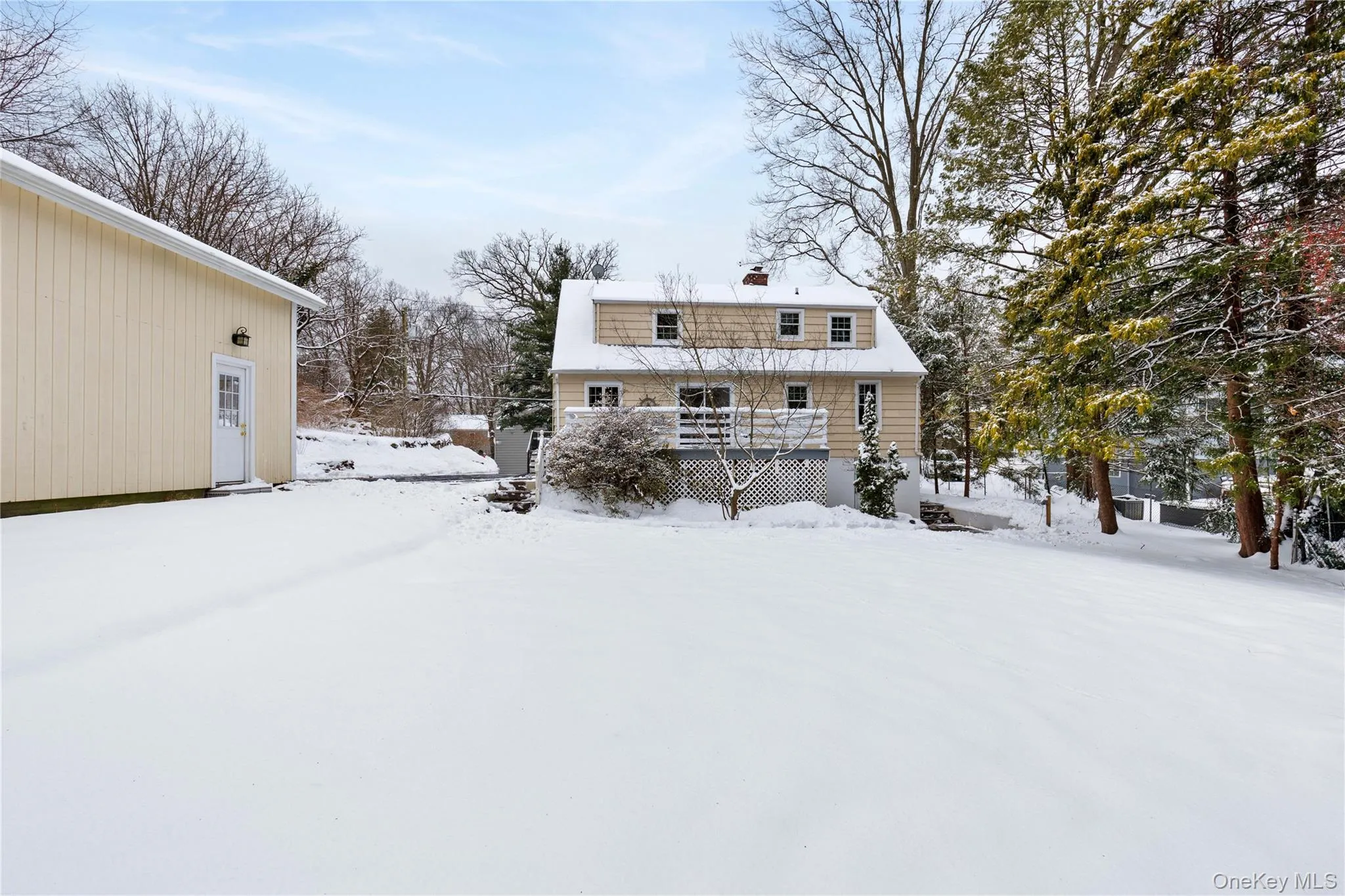 Snow covered rear of property featuring a chimney and a wooden deck Snow covered rear of property featuring a chimney and a wooden deck