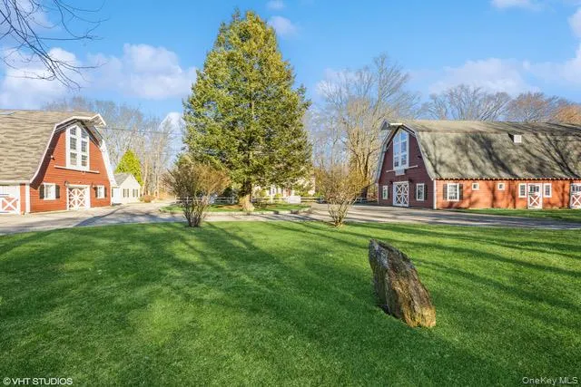 View of green lawn featuring a barn and an outbuilding View of green lawn featuring a barn and an outbuilding