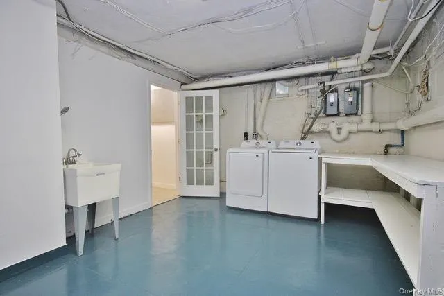 Laundry room featuring finished concrete floors and washer and dryer Laundry room featuring finished concrete floors and washer and dryer