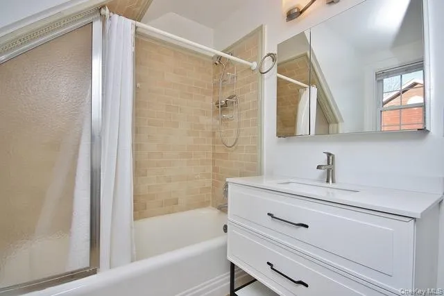 Bathroom featuring shower / bathtub combination with curtain and vanity Bathroom featuring shower / bathtub combination with curtain and vanity