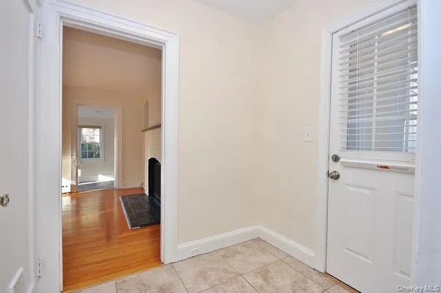 Doorway to outside featuring tile patterned flooring and a fireplace Doorway to outside featuring tile patterned flooring and a fireplace