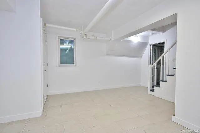 Basement featuring stairs and light tile patterned floors Basement featuring stairs and light tile patterned floors