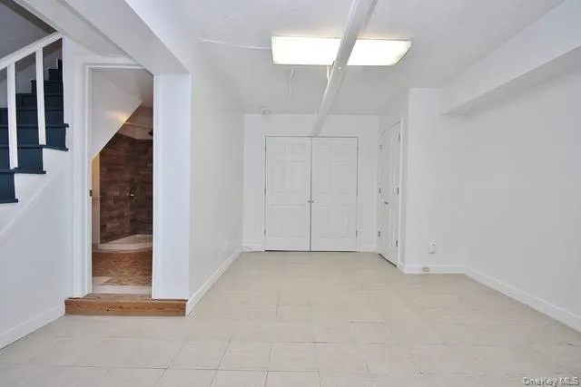 Unfurnished bedroom with light tile patterned floors and ensuite bath Unfurnished bedroom with light tile patterned floors and ensuite bath