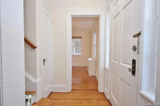 Hall with light wood-style flooring and baseboards Hall with light wood-style flooring and baseboards