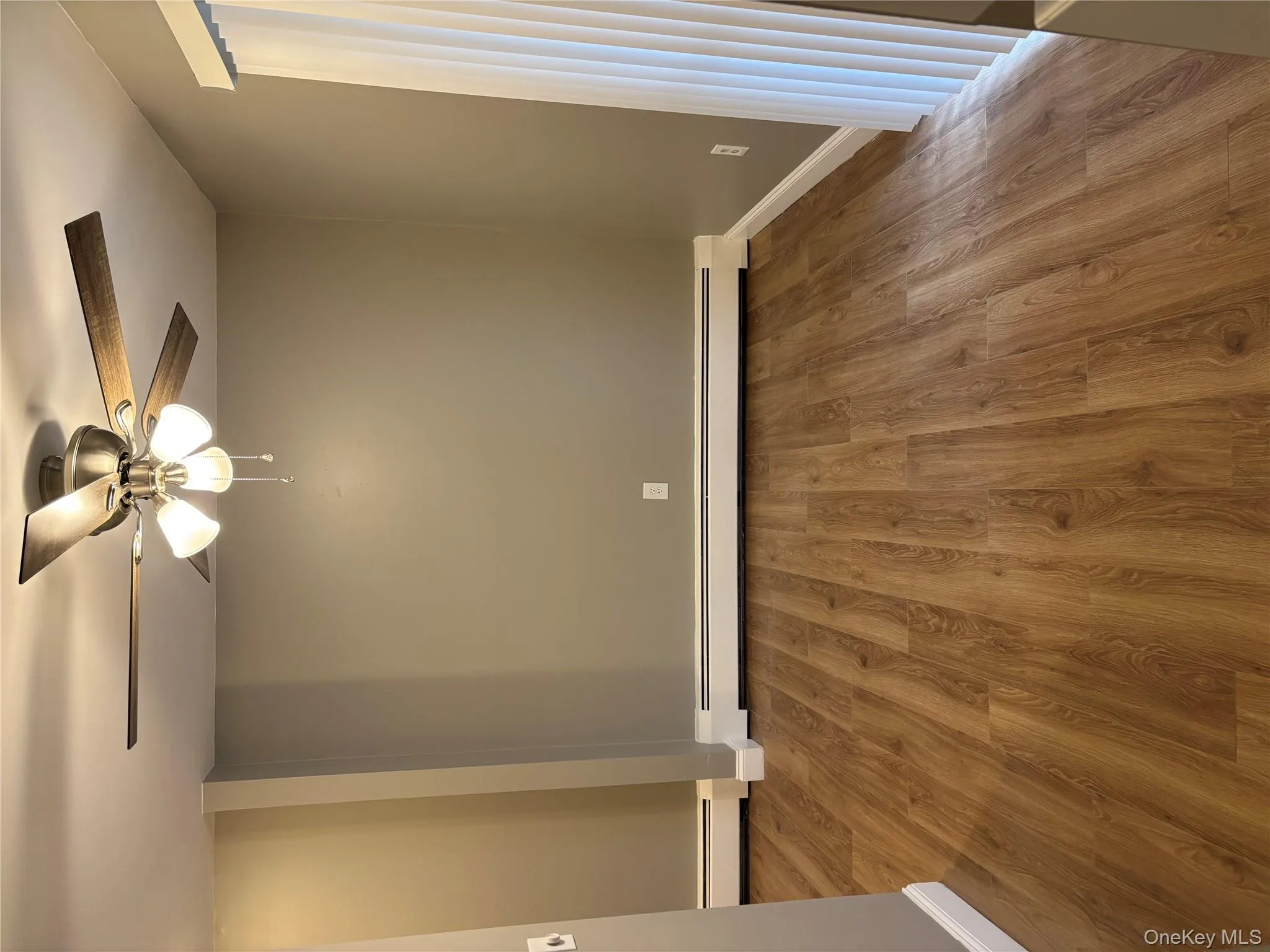 Empty room featuring wood finished floors, baseboard heating, and ceiling fan Empty room featuring wood finished floors, baseboard heating, and ceiling fan