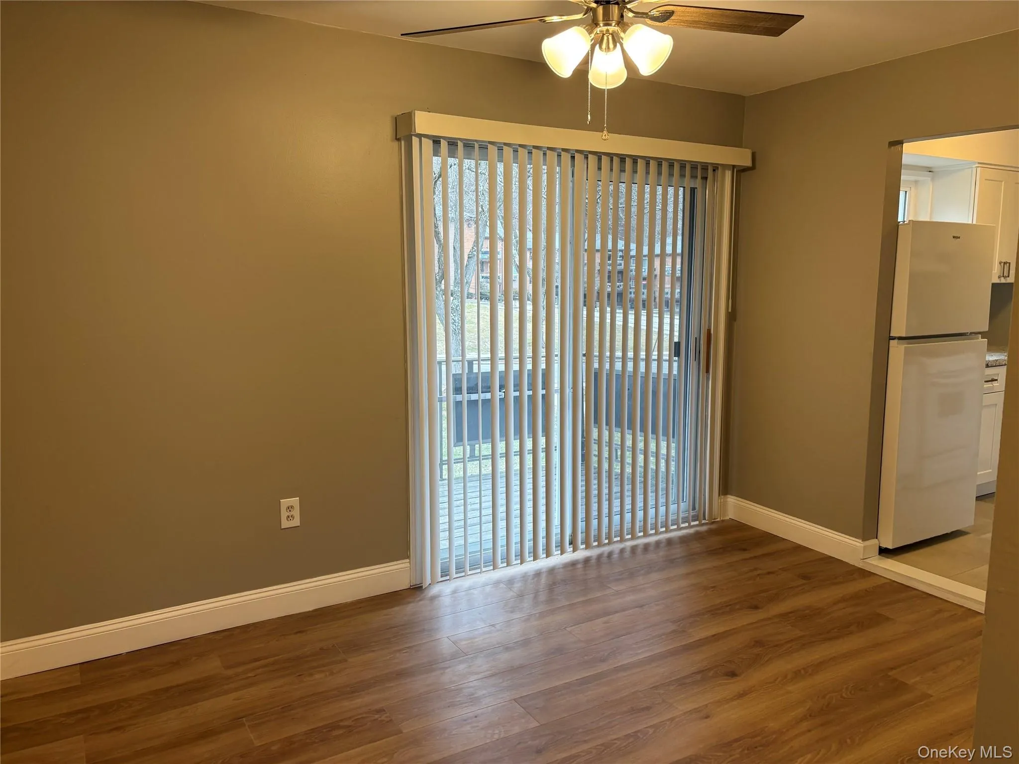 Unfurnished room featuring dark wood-type flooring and a ceiling fan Unfurnished room featuring dark wood-type flooring and a ceiling fan