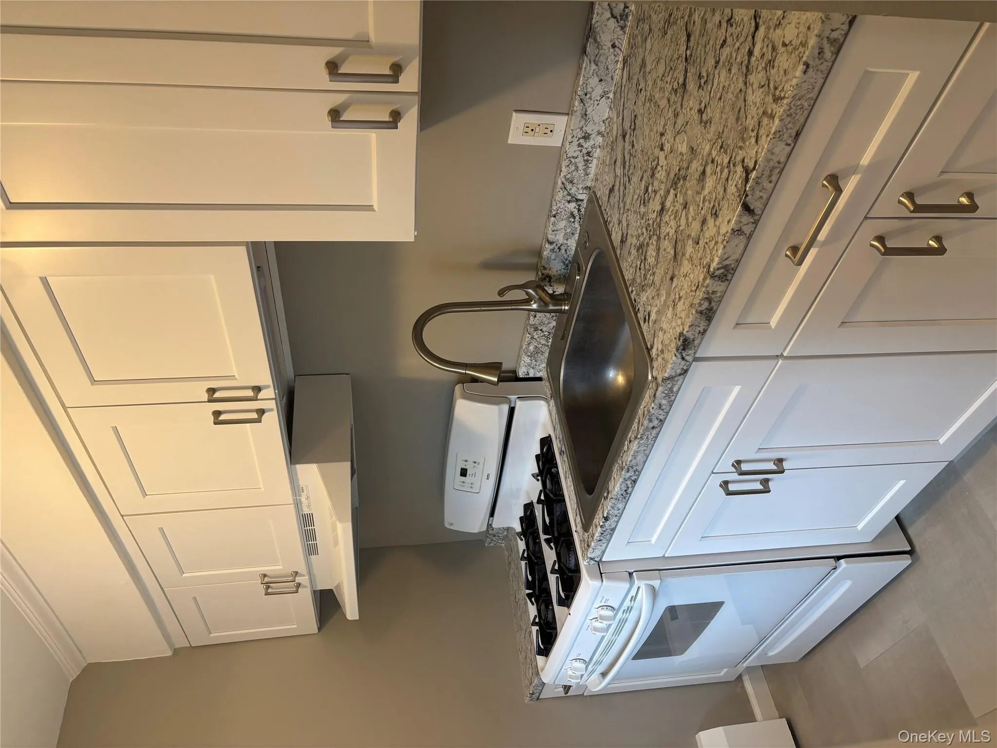 Kitchen with white stove, white cabinetry, ventilation hood, and light stone counters Kitchen with white stove, white cabinetry, ventilation hood, and light stone counters