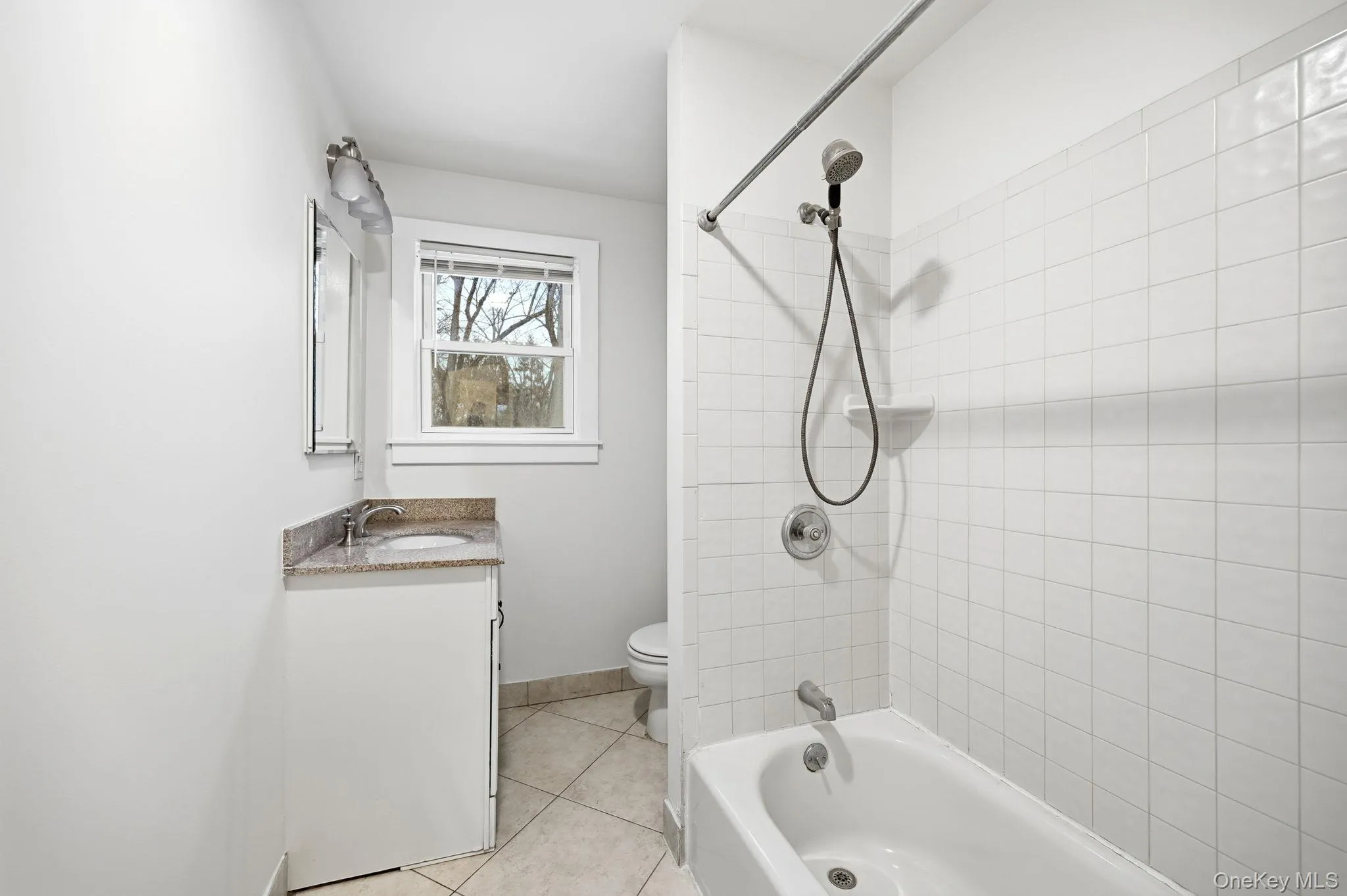 Full bath with shower / bathtub combination, vanity, and light tile patterned floors Full bath with shower / bathtub combination, vanity, and light tile patterned floors