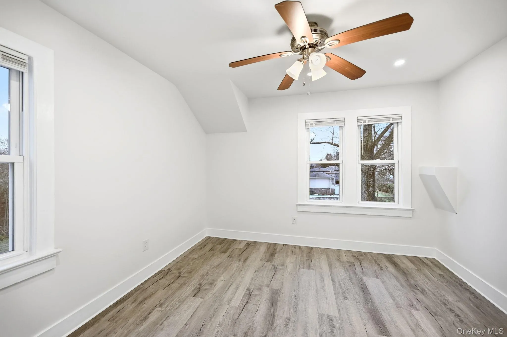 Additional living space featuring light wood-type flooring, ceiling fan, and healthy amount of natural light Additional living space featuring light wood-type flooring, ceiling fan, and healthy amount of natural light