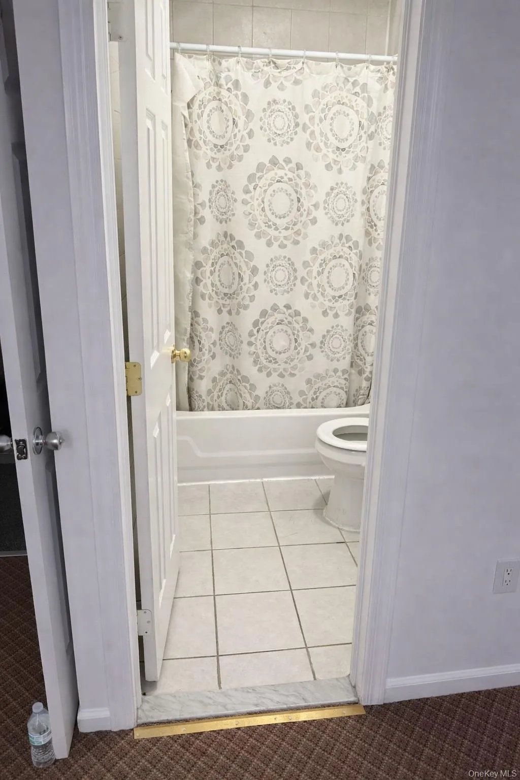 Bathroom featuring shower / bath combination with curtain and light tile patterned floors Bathroom featuring shower / bath combination with curtain and light tile patterned floors