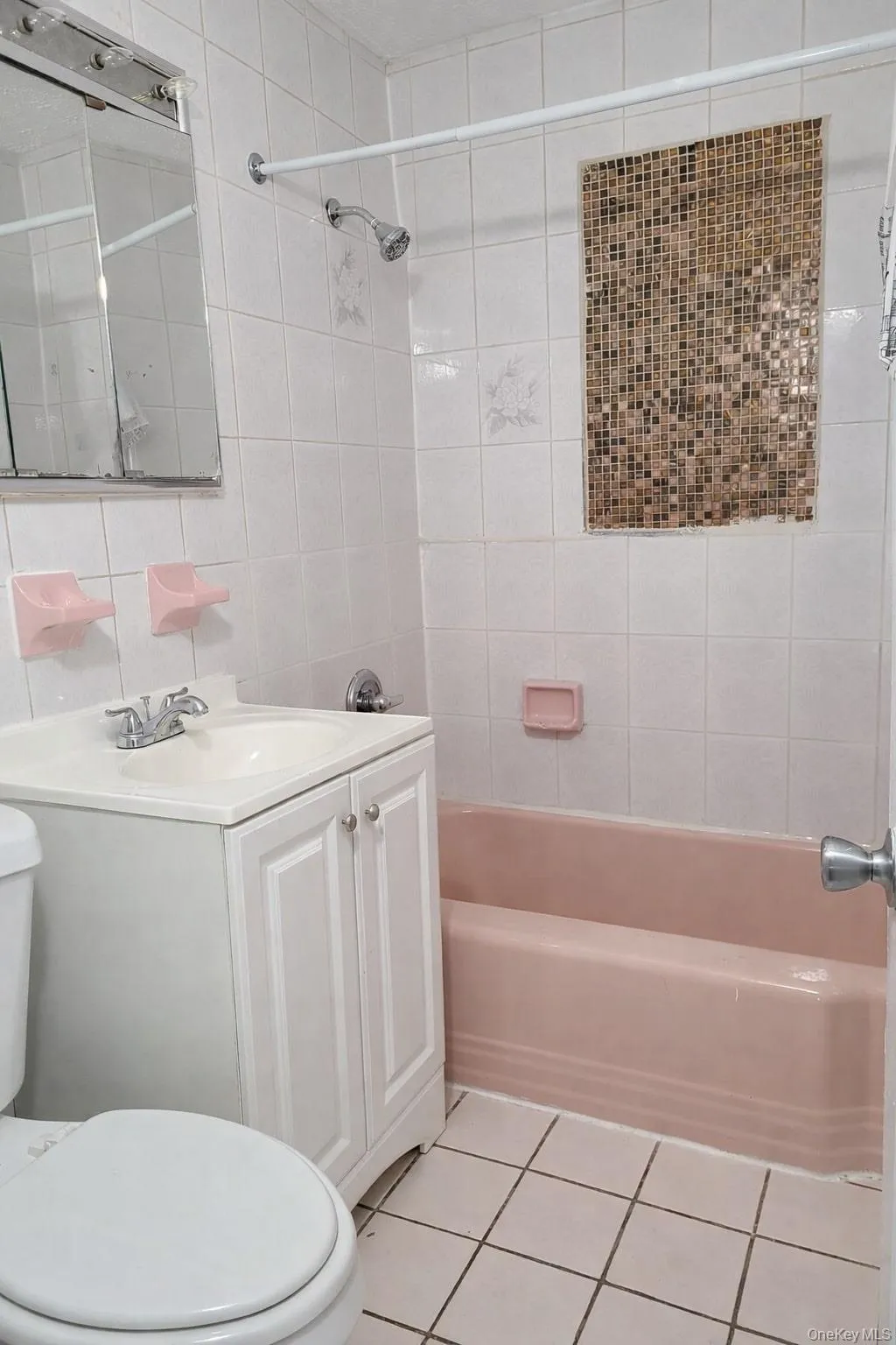 Bathroom with bathing tub / shower combination, vanity, light tile patterned flooring, and tile walls Bathroom with bathing tub / shower combination, vanity, light tile patterned flooring, and tile walls