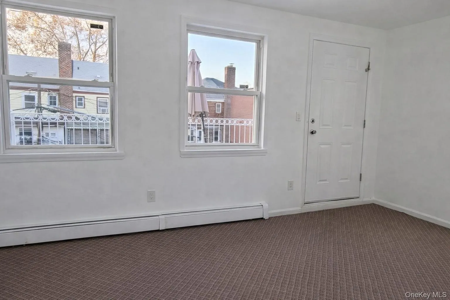 Carpeted empty room featuring a baseboard radiator and baseboards Carpeted empty room featuring a baseboard radiator and baseboards