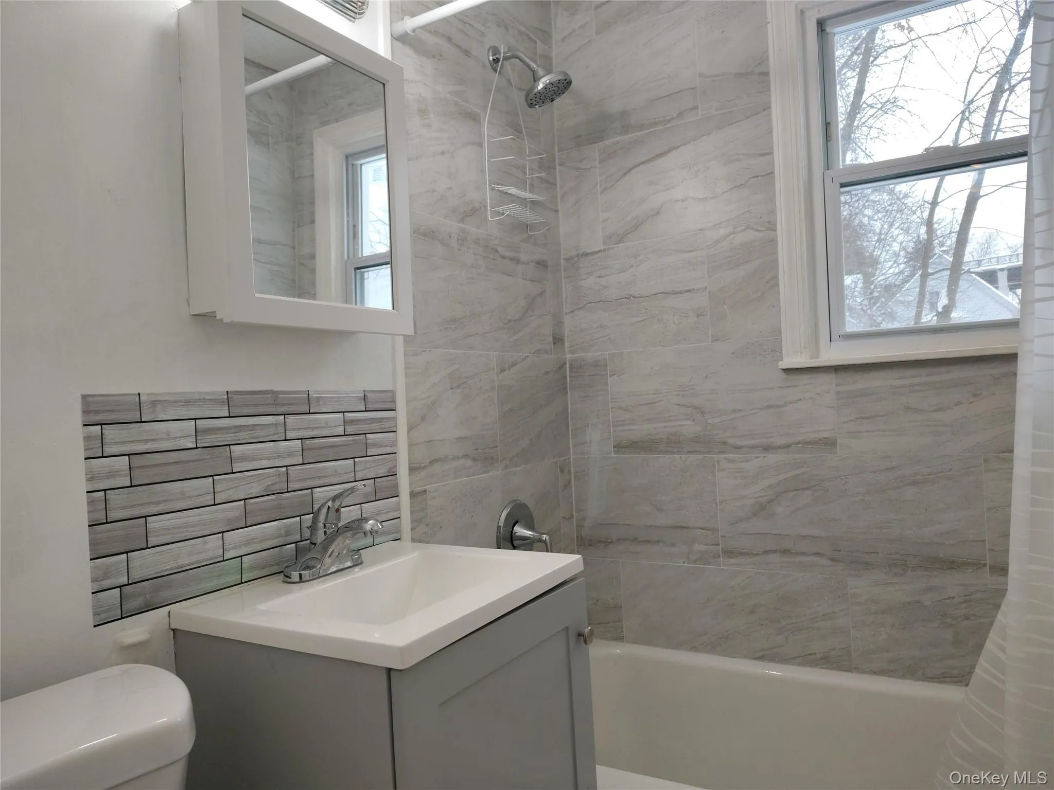Full bath with shower / tub combo with curtain, vanity, and tasteful backsplash Full bath with shower / tub combo with curtain, vanity, and tasteful backsplash