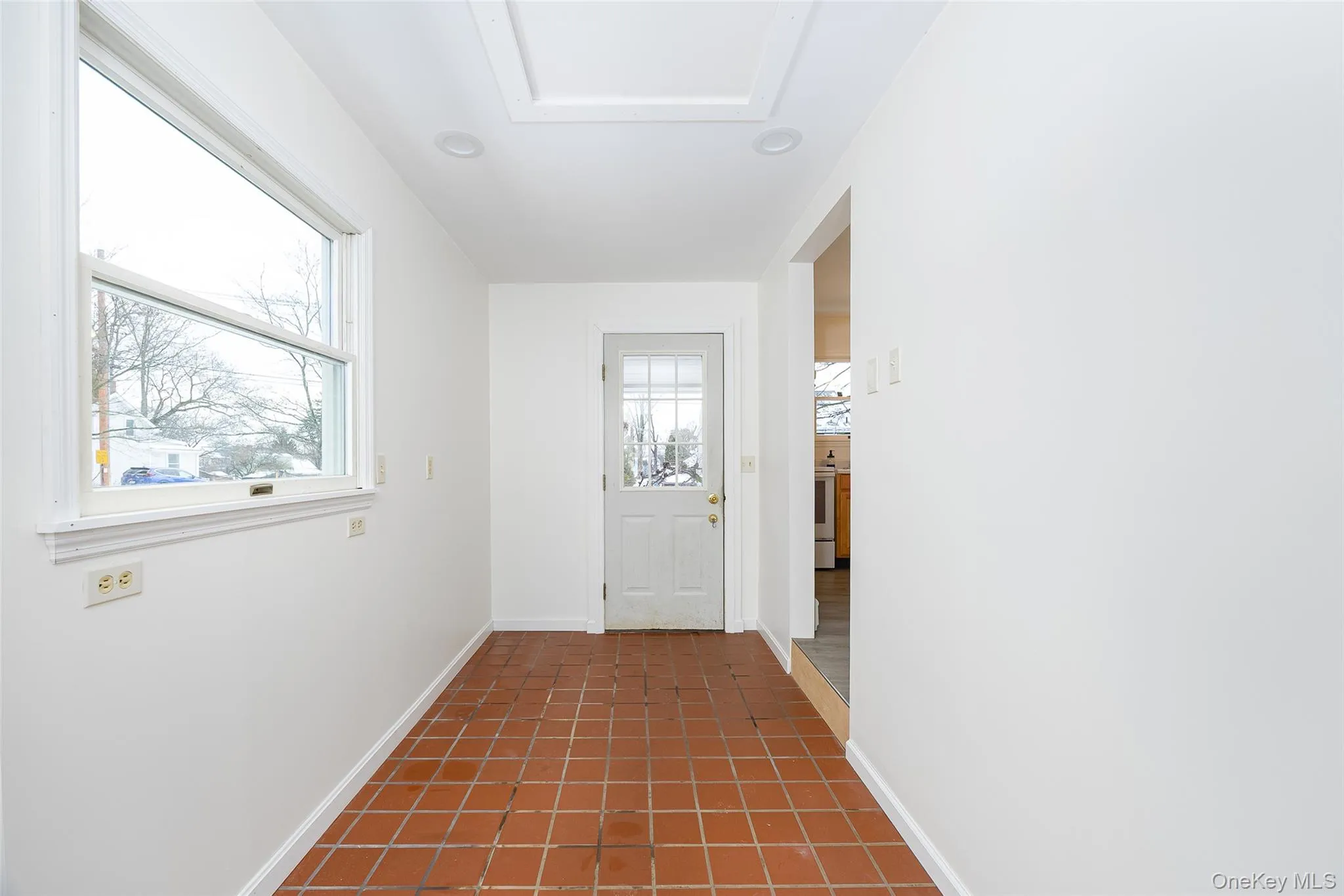 Doorway featuring tile patterned floors and baseboards Doorway featuring tile patterned floors and baseboards