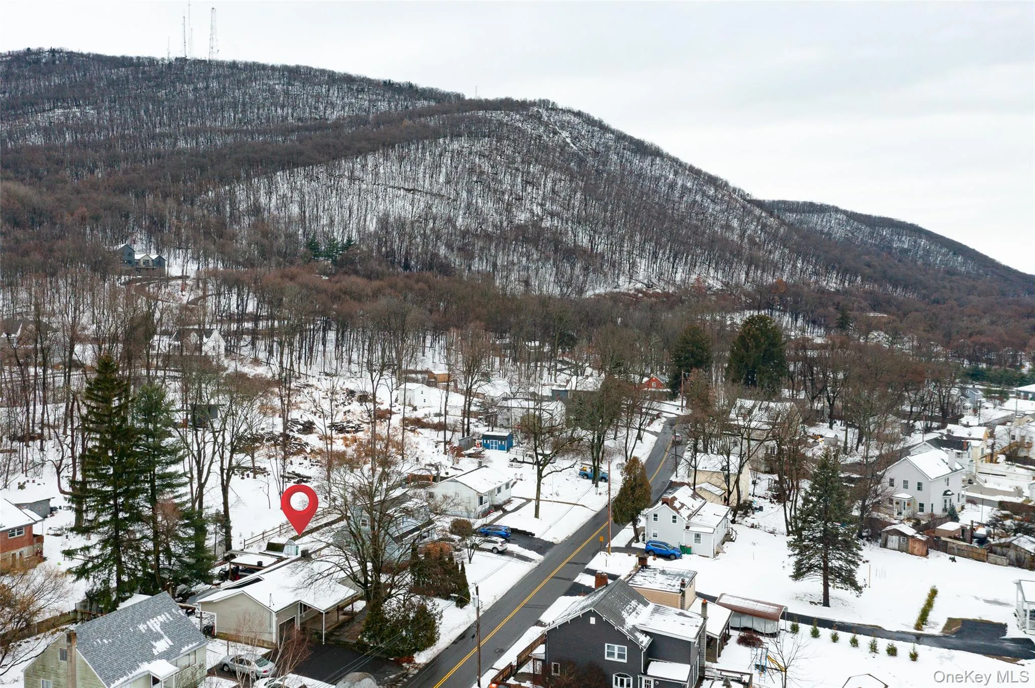 Snowy aerial view with a mountain view and a residential view Snowy aerial view with a mountain view and a residential view