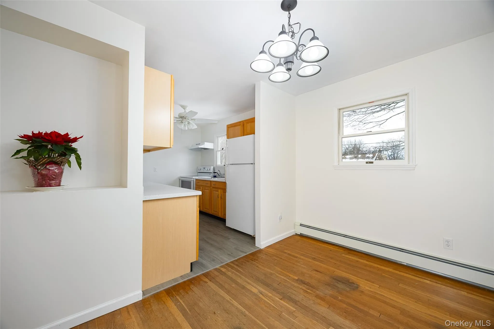 Kitchen with light countertops, white appliances, plenty of natural light, and a chandelier Kitchen with light countertops, white appliances, plenty of natural light, and a chandelier