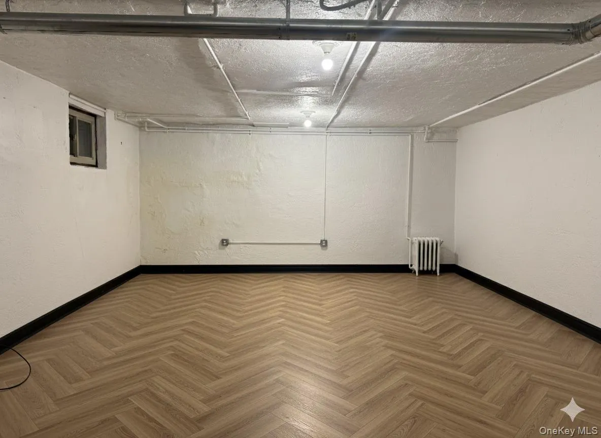 To be renovated basement rendering with a textured wall and radiator heating unit To be renovated basement rendering with a textured wall and radiator heating unit