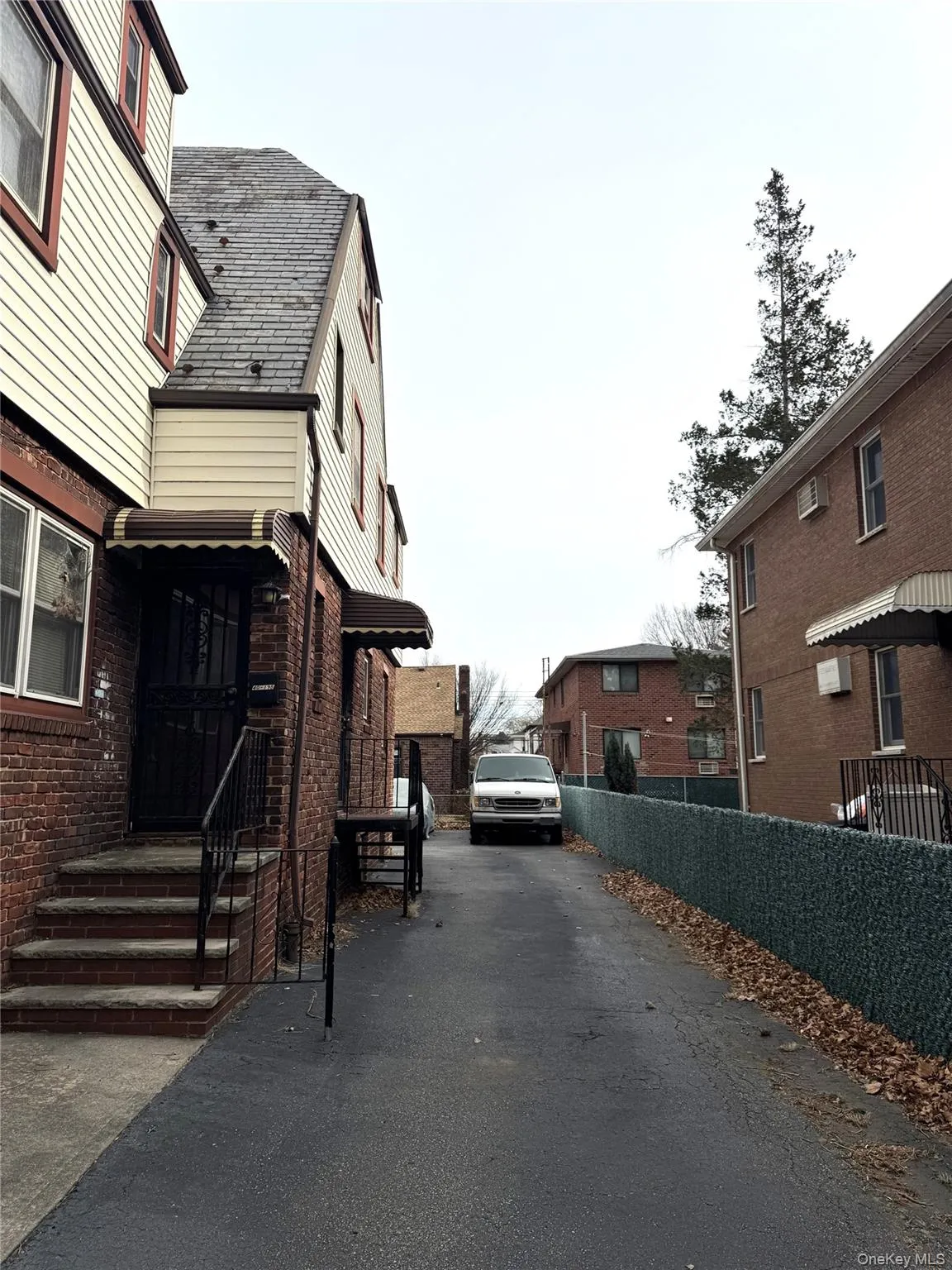 View of side of property featuring a high end roof, a residential view, and asphalt driveway View of side of property featuring a high end roof, a residential view, and asphalt driveway