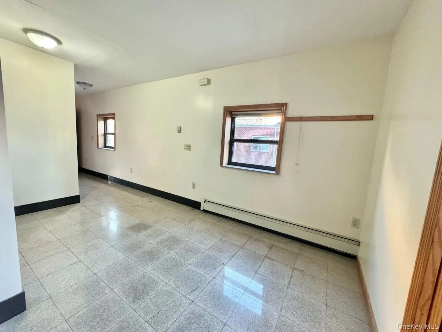 Spare room featuring baseboard heating and granite floors Spare room featuring baseboard heating and granite floors