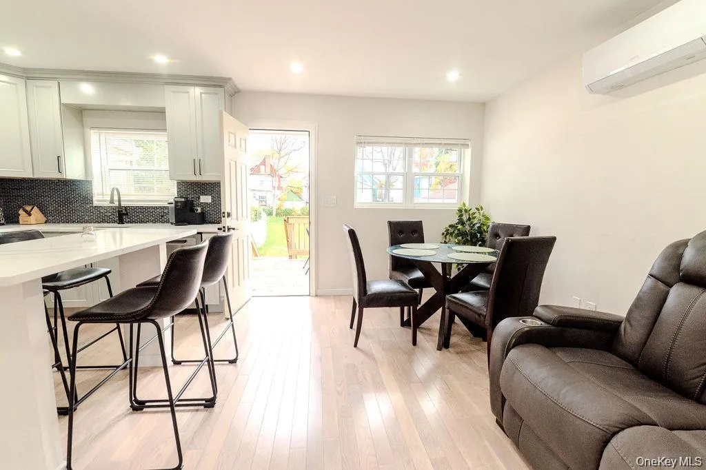 Dining space featuring an AC wall unit, light wood-style floors, and recessed lighting Dining space featuring an AC wall unit, light wood-style floors, and recessed lighting