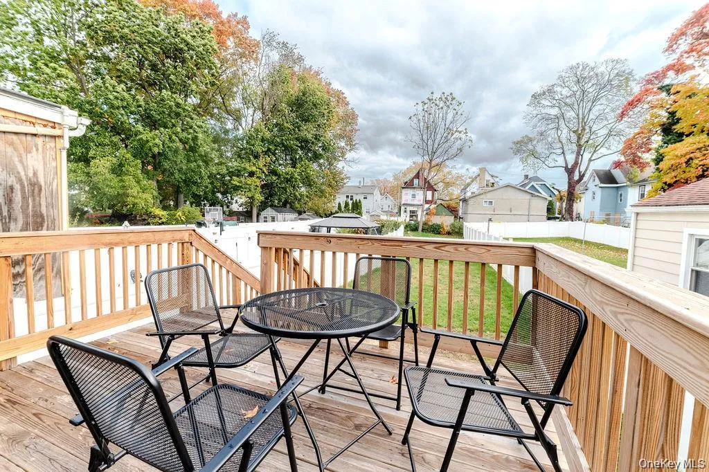 Wooden deck featuring a residential view and outdoor dining area Wooden deck featuring a residential view and outdoor dining area