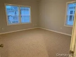 Empty room with baseboards and carpet floors Empty room with baseboards and carpet floors
