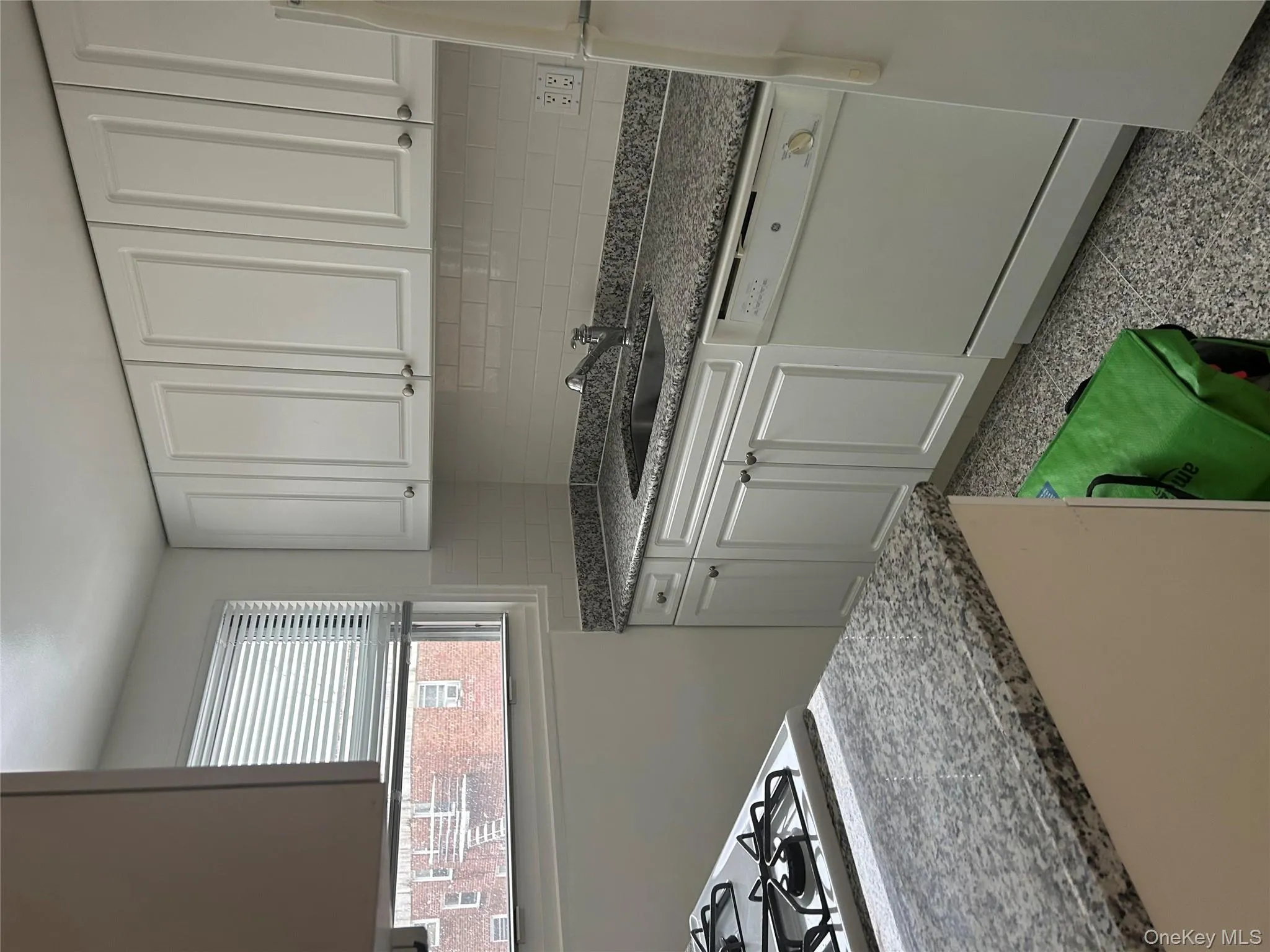 Kitchen with white cabinets, dishwasher, fridge, dark aggregate flooring, and tasteful backsplash Kitchen with white cabinets, dishwasher, fridge, dark aggregate flooring, and tasteful backsplash