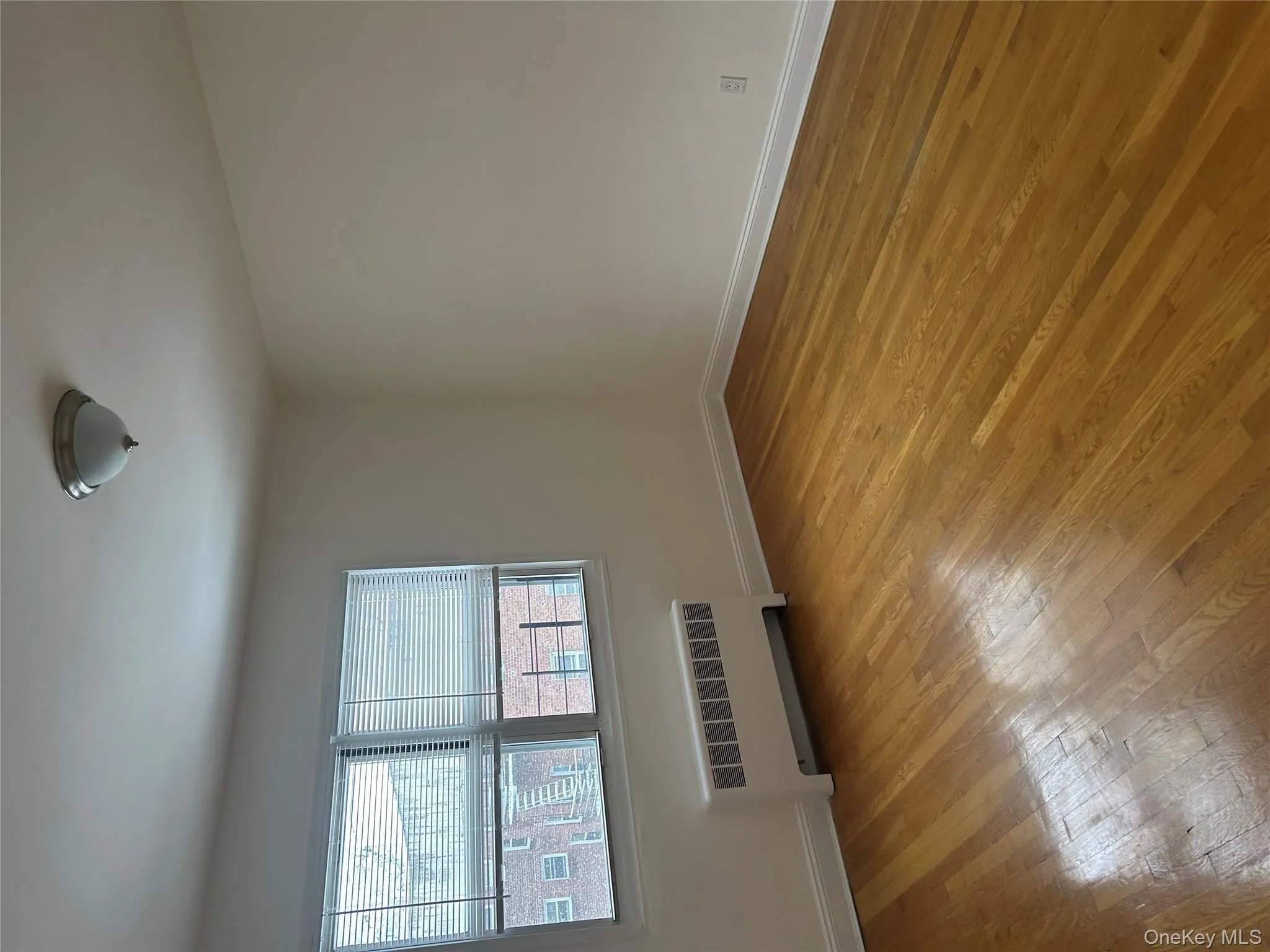 Unfurnished room with radiator and light wood-style flooring Unfurnished room with radiator and light wood-style flooring