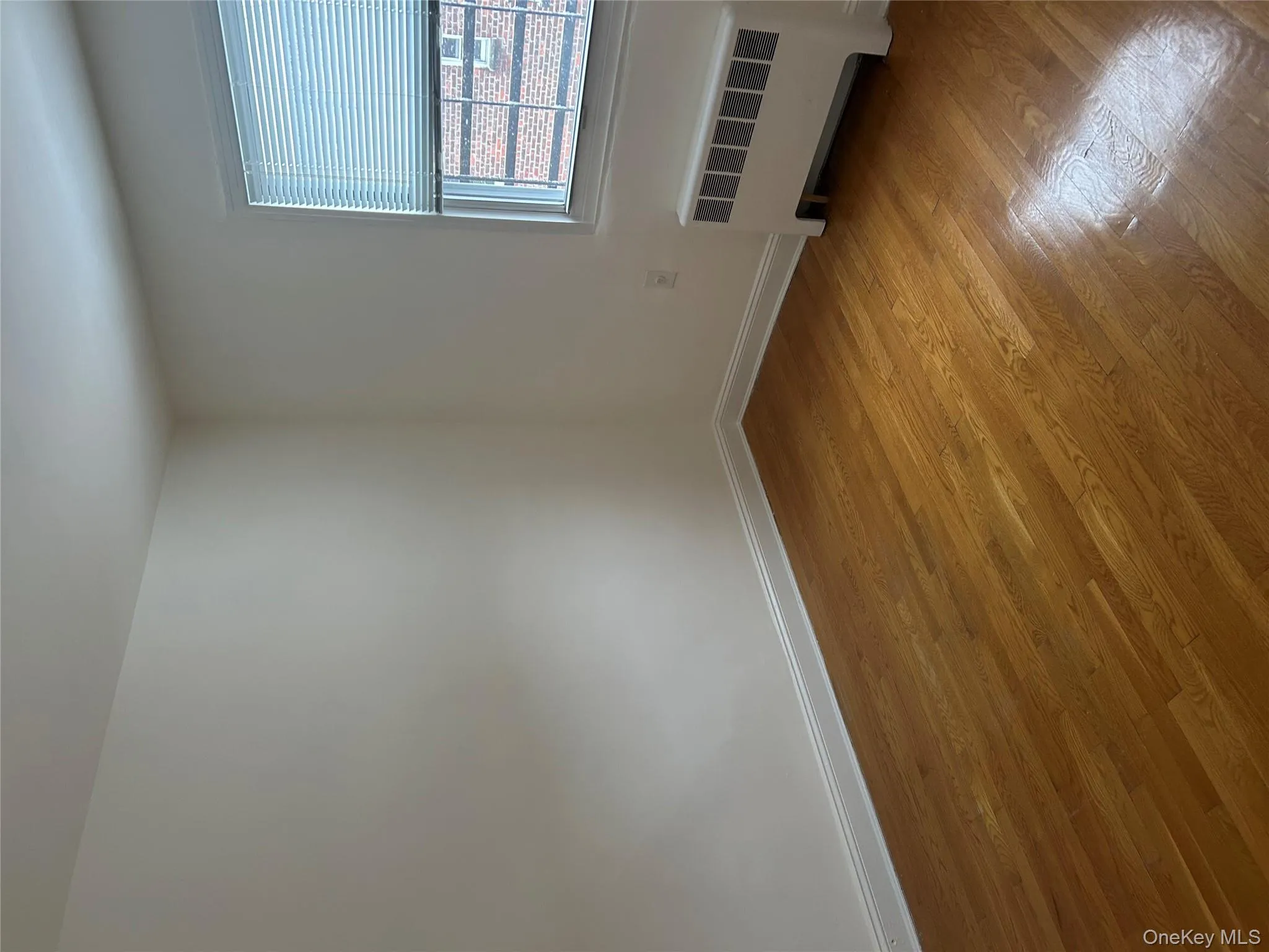 Spare room with radiator and light wood-style flooring Spare room with radiator and light wood-style flooring