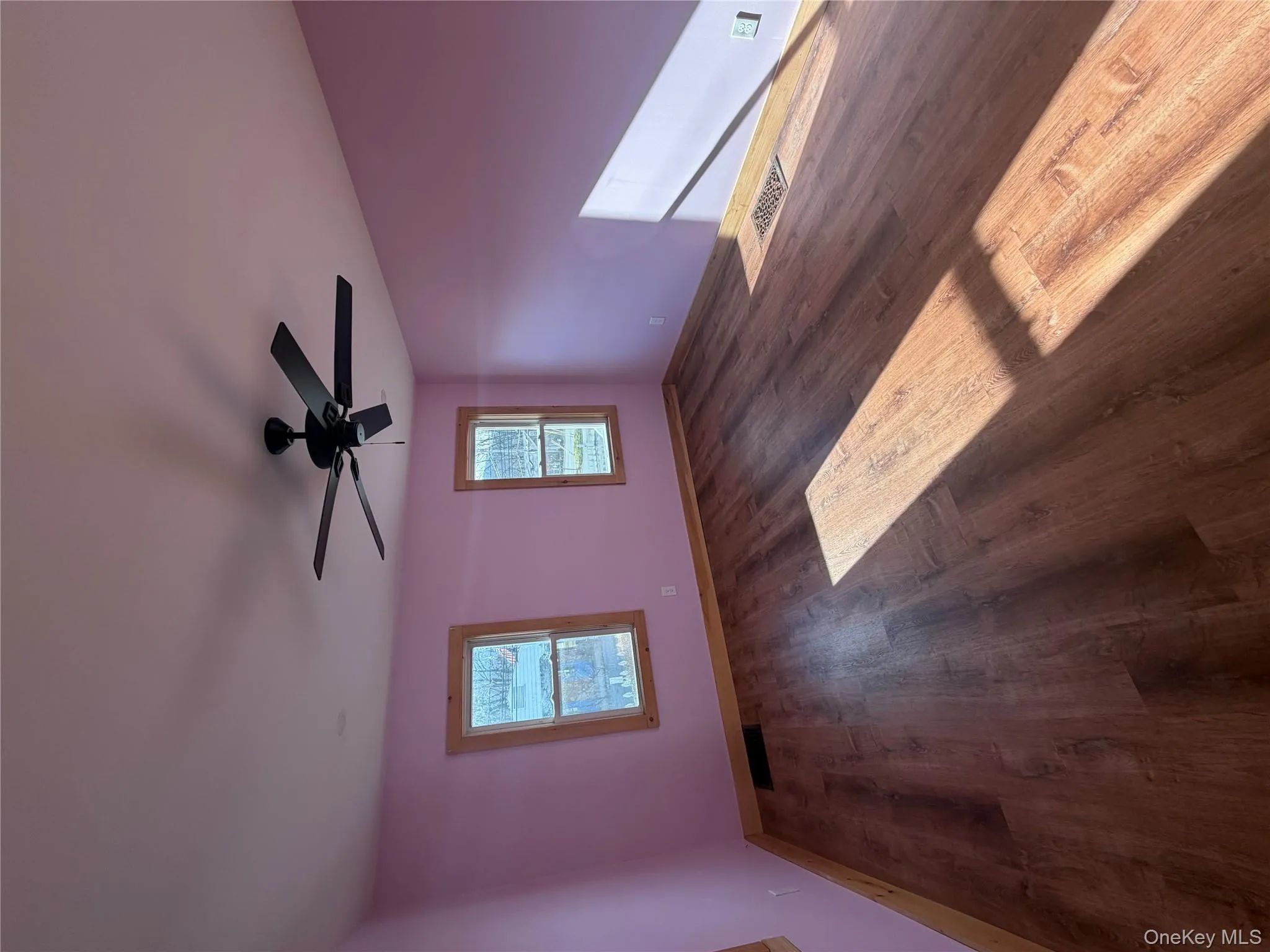 Empty room featuring dark wood-style flooring and a ceiling fan Empty room featuring dark wood-style flooring and a ceiling fan