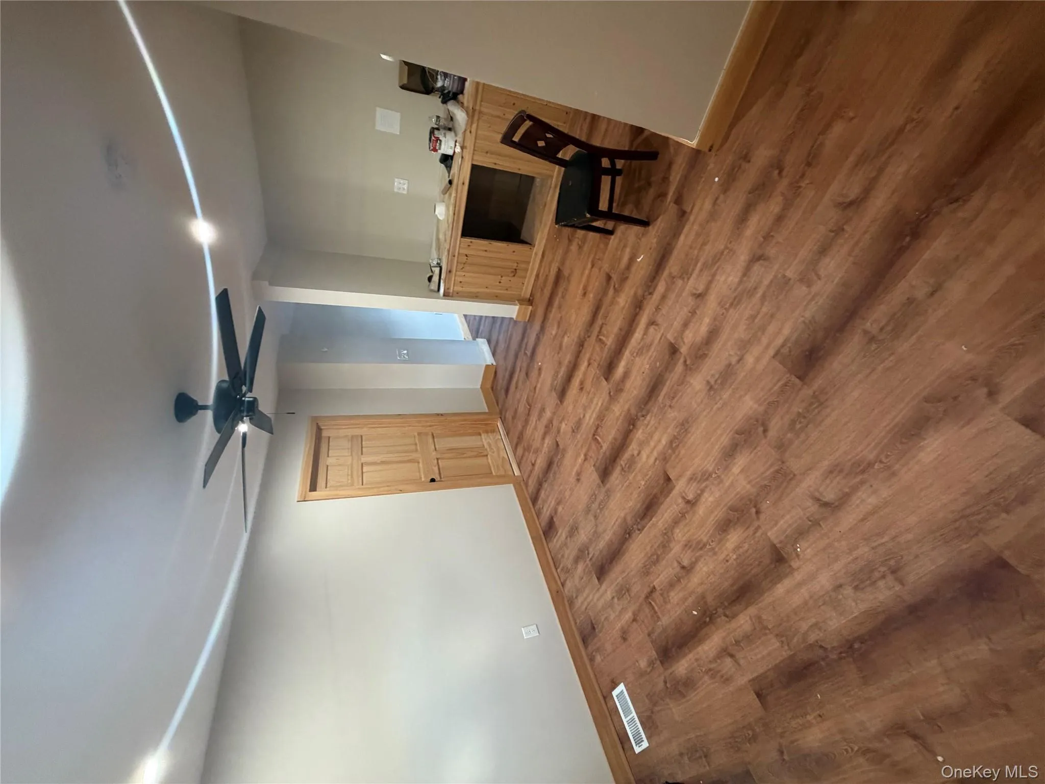 Unfurnished office featuring dark wood-type flooring and a ceiling fan Unfurnished office featuring dark wood-type flooring and a ceiling fan