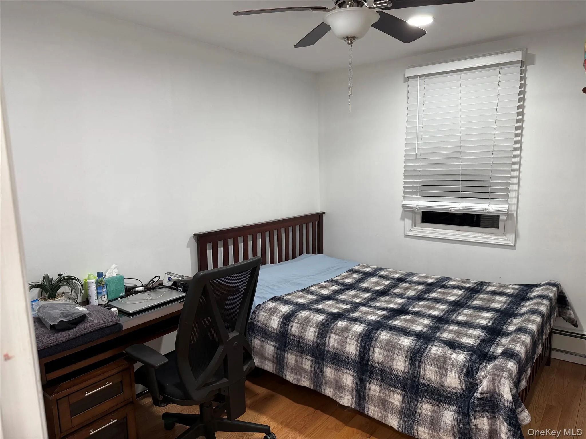 Bedroom featuring wood finished floors, ceiling fan, and a desk Bedroom featuring wood finished floors, ceiling fan, and a desk
