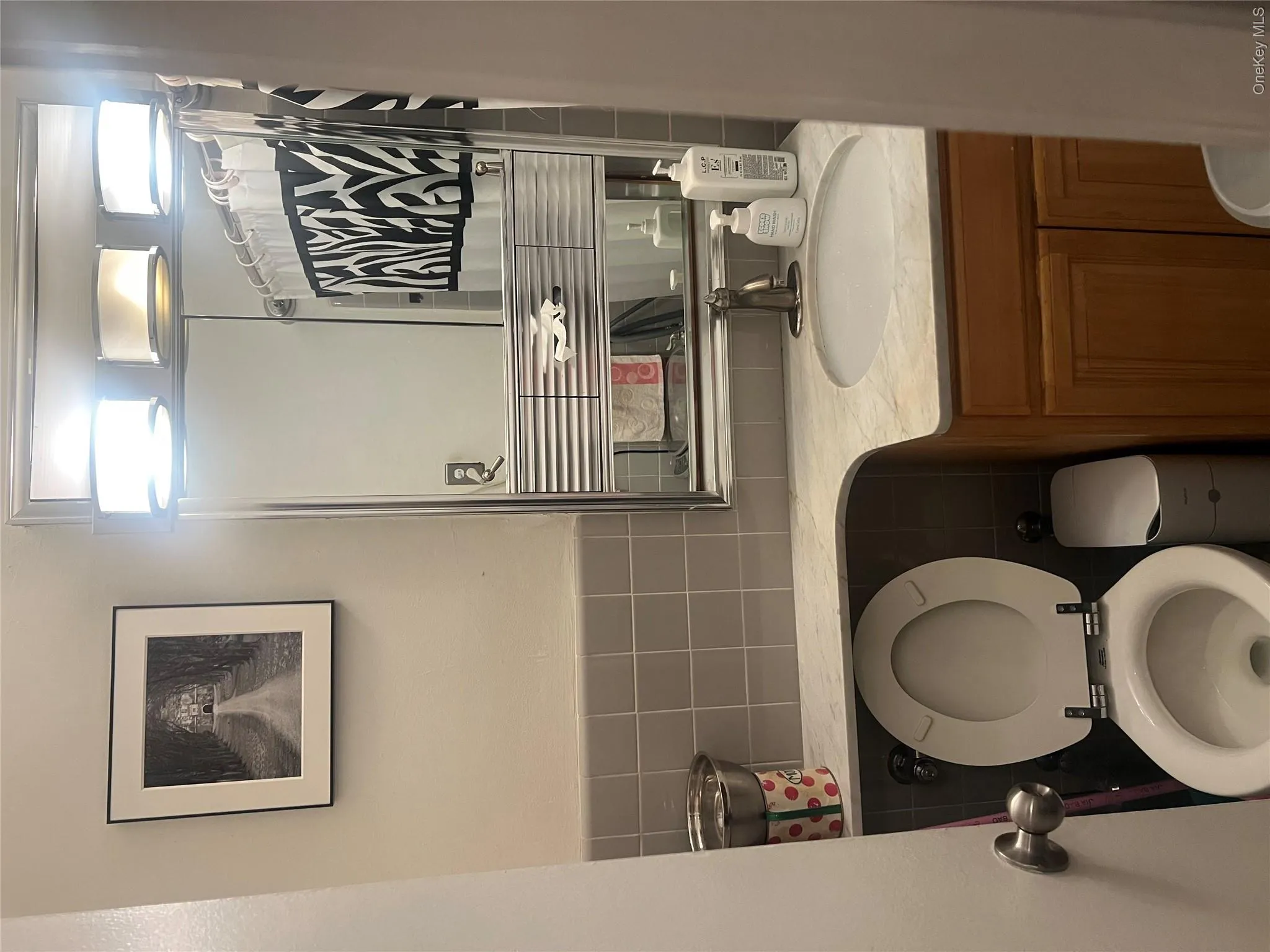 Bathroom featuring vanity, curtained shower, and tile walls Bathroom featuring vanity, curtained shower, and tile walls