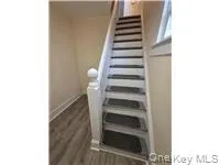 Staircase featuring wood finished floors and baseboards Staircase featuring wood finished floors and baseboards