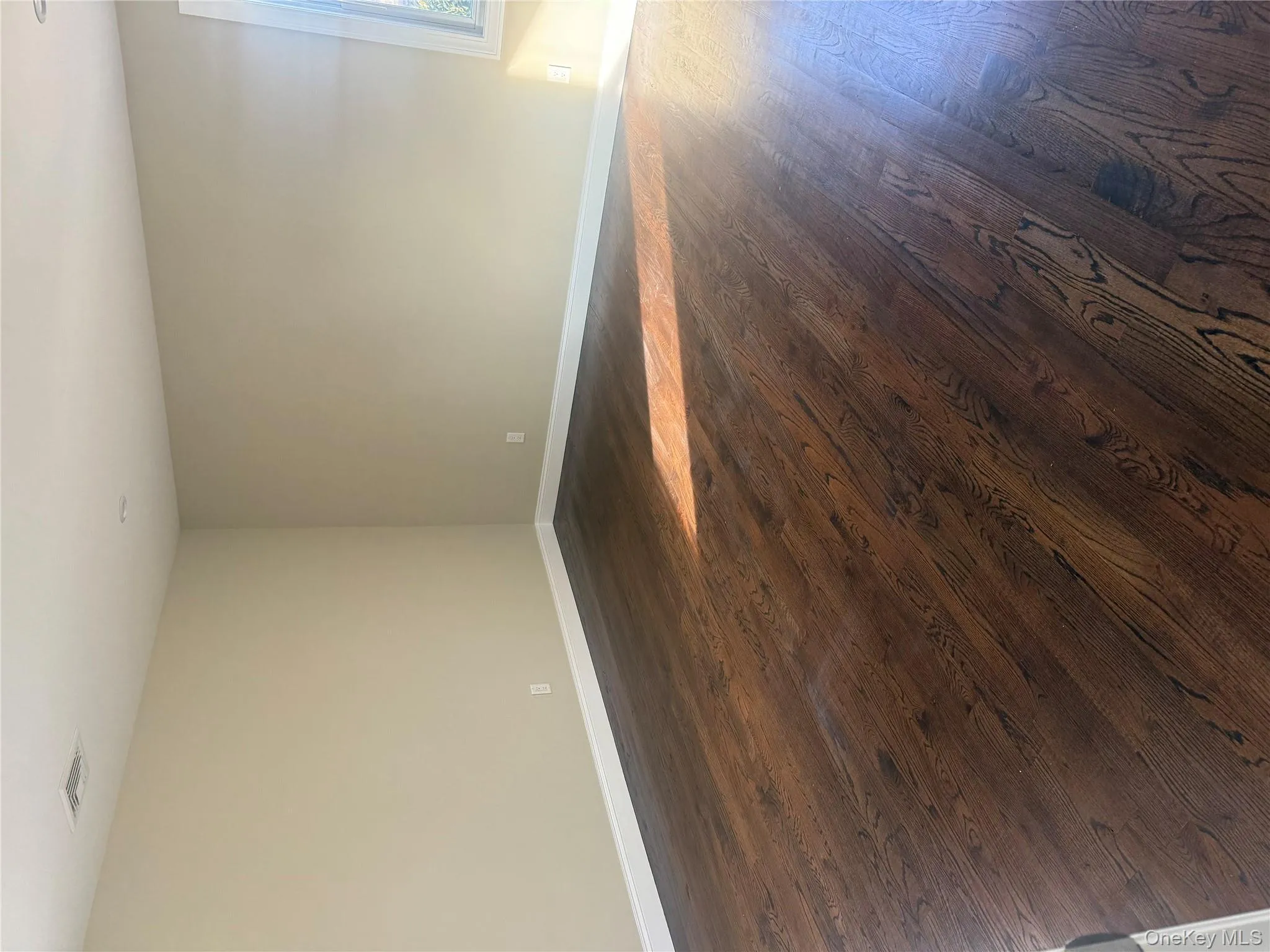 Spare room featuring baseboards and dark wood finished floors Spare room featuring baseboards and dark wood finished floors