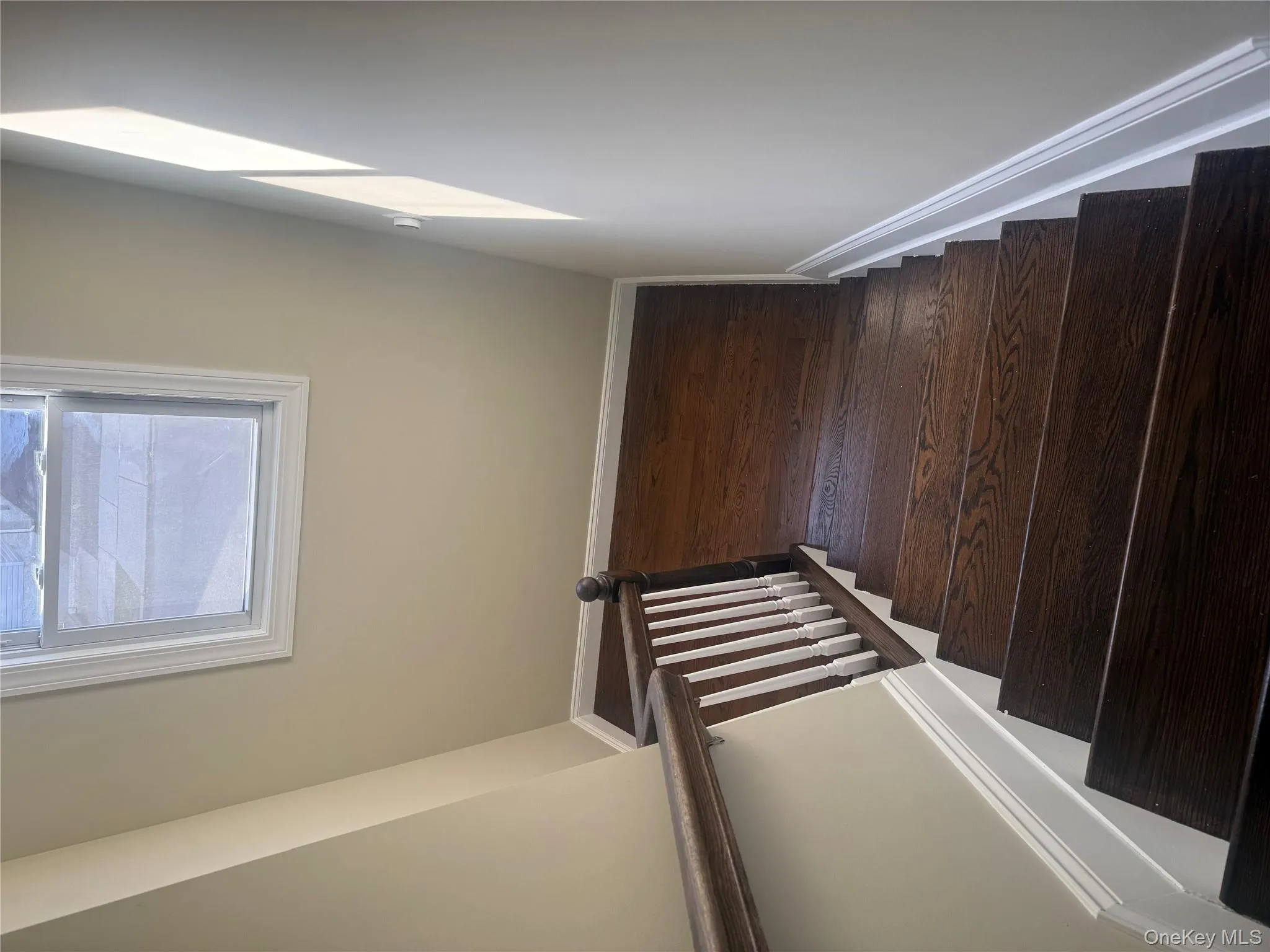 Stairway featuring baseboards and hardwood / wood-style flooring Stairway featuring baseboards and hardwood / wood-style flooring