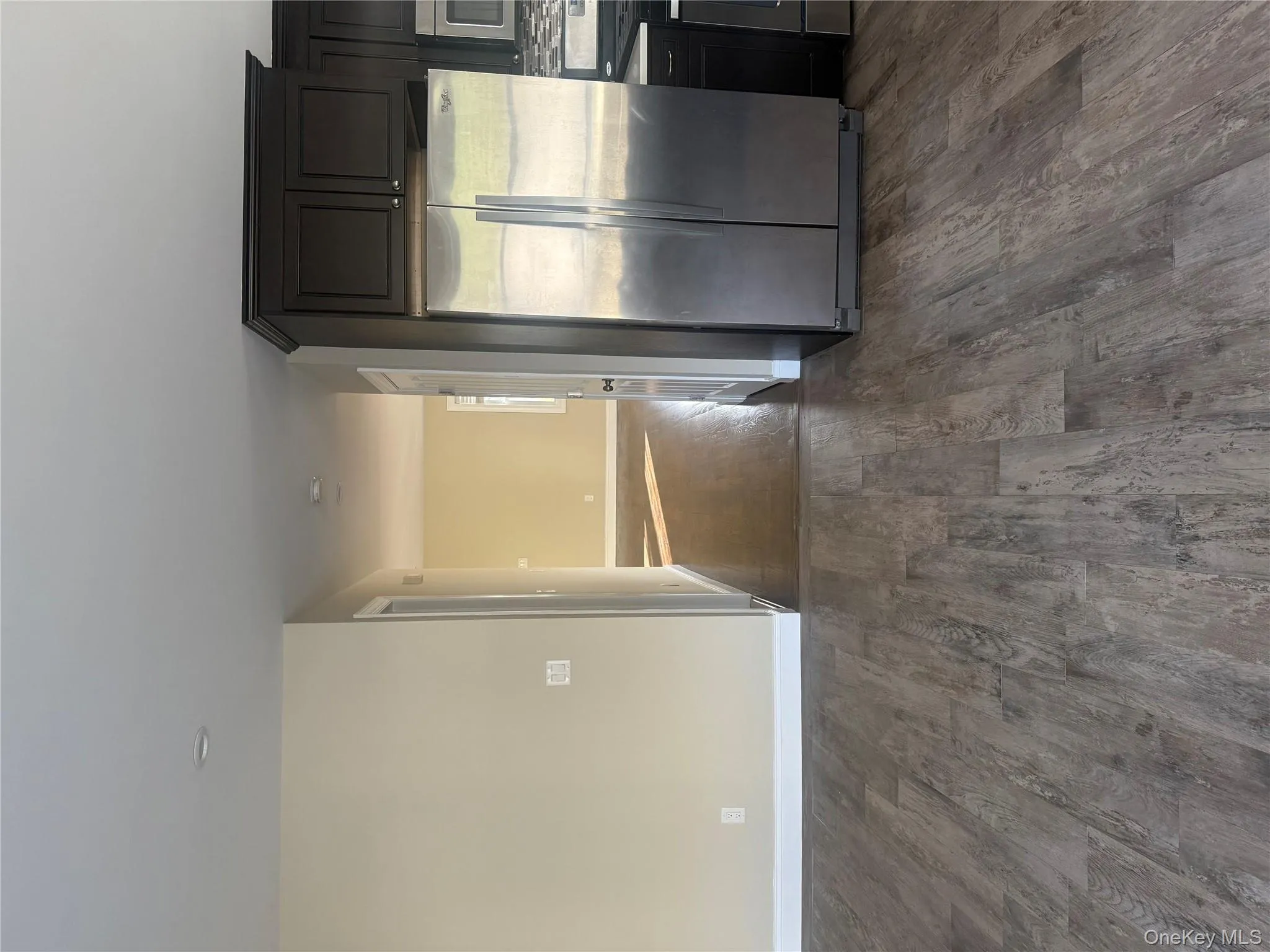 Kitchen with fridge, range, and dark wood-style flooring Kitchen with fridge, range, and dark wood-style flooring