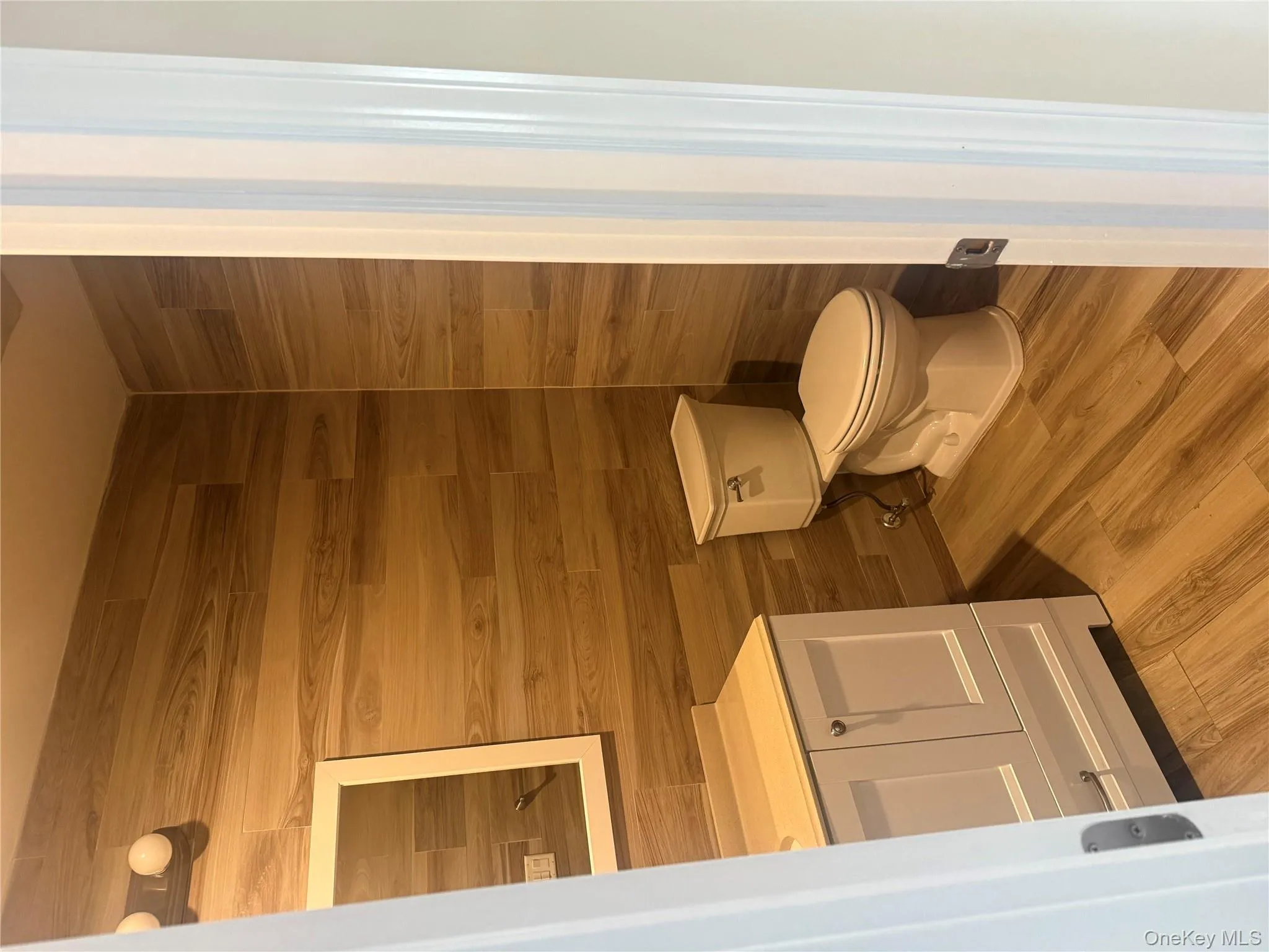 Half bath featuring vanity and light wood-style flooring Half bath featuring vanity and light wood-style flooring