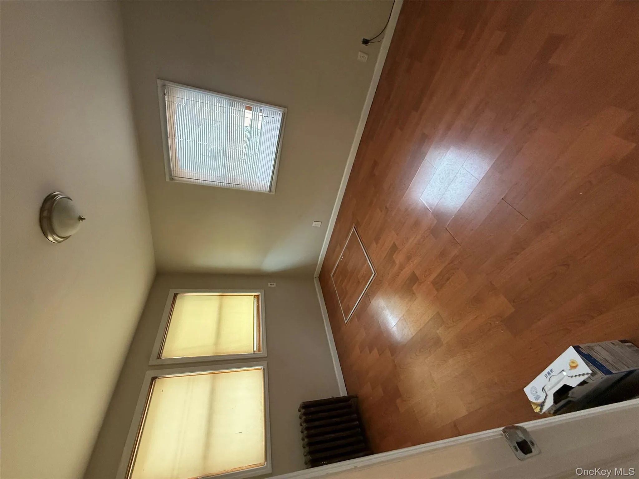 Spare room featuring radiator and light wood-type flooring Spare room featuring radiator and light wood-type flooring