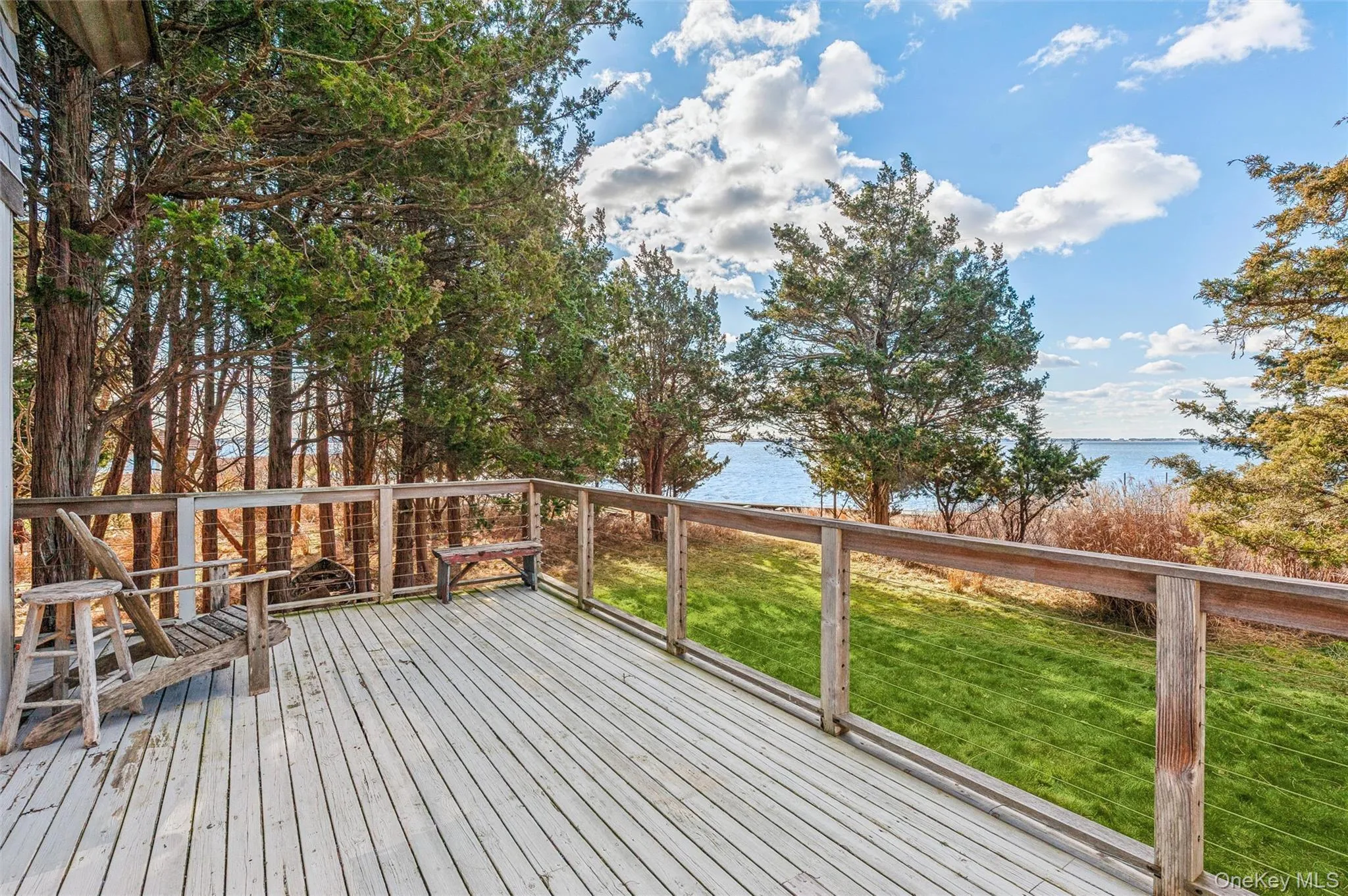 Wooden terrace featuring a yard and a water view Wooden terrace featuring a yard and a water view