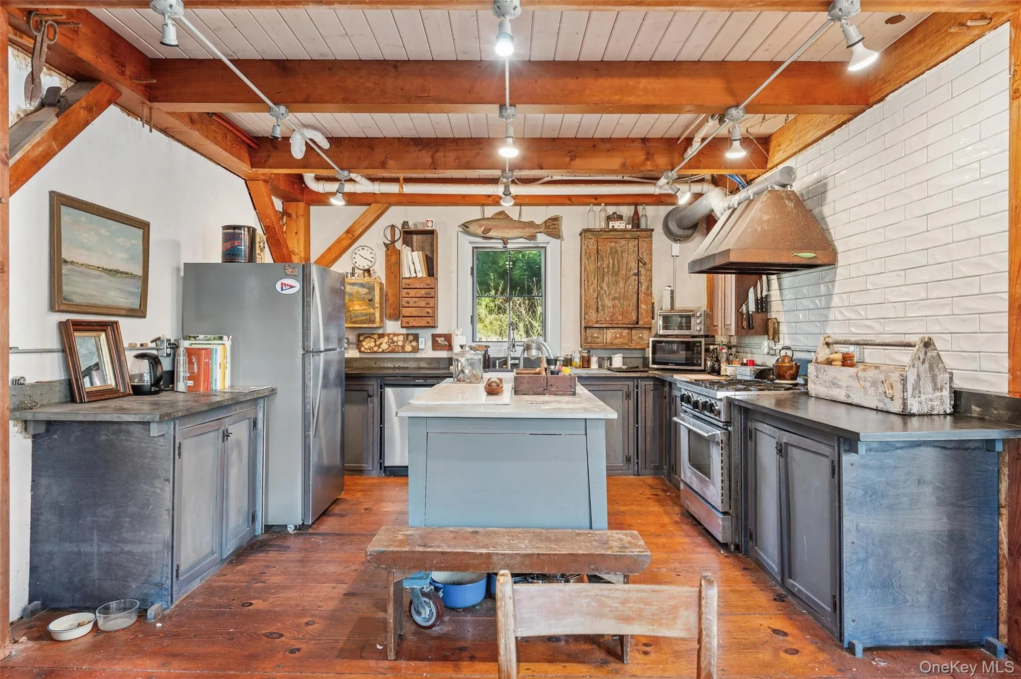 Kitchen featuring gray cabinetry, a kitchen island, stainless steel appliances, a wooden ceiling with exposed beams, and track lighting Kitchen featuring gray cabinetry, a kitchen island, stainless steel appliances, a wooden ceiling with exposed beams, and track lighting