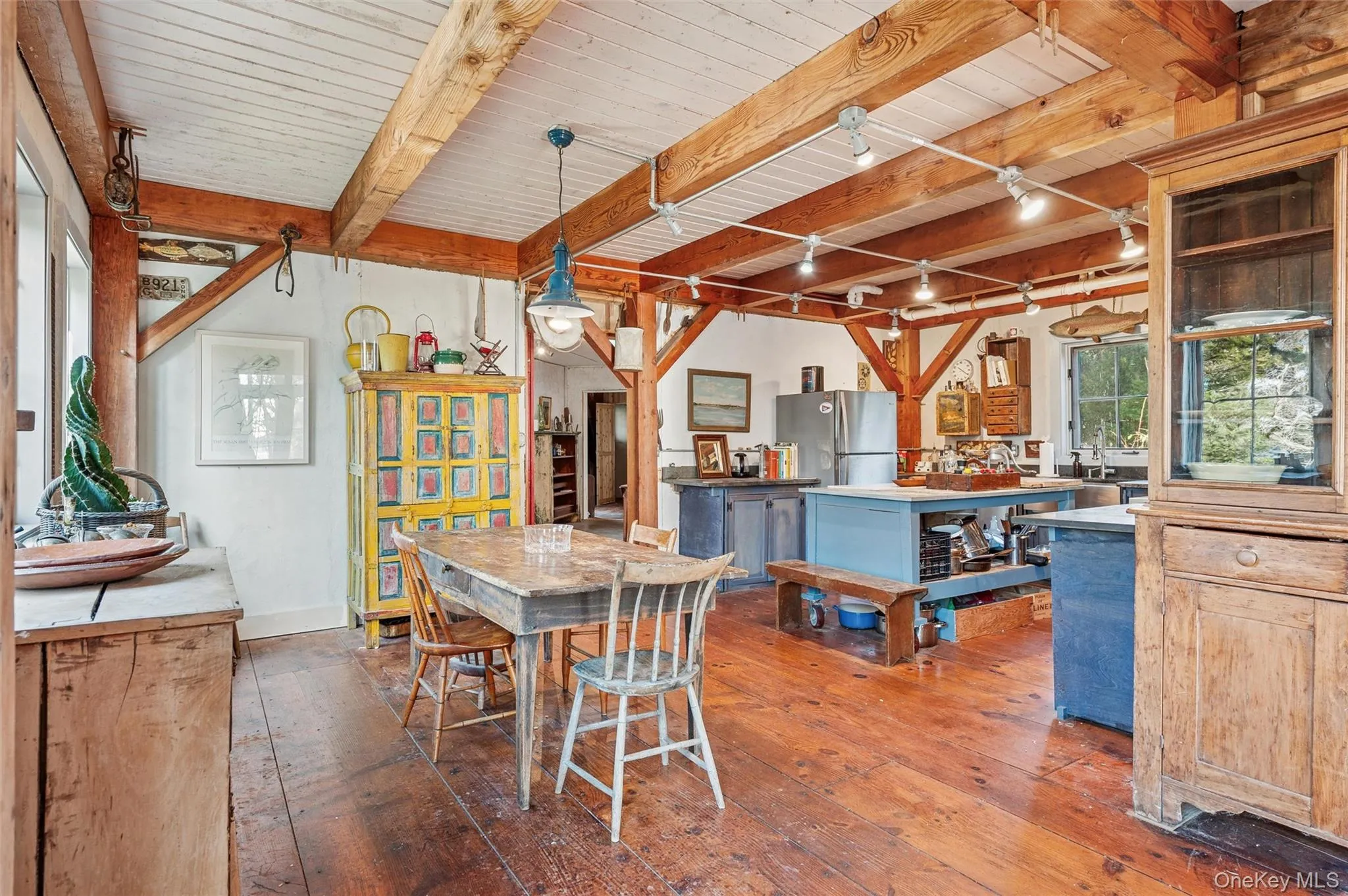 Dining area featuring a wood ceiling with exposed beams, dark wood-style flooring, and track lighting Dining area featuring a wood ceiling with exposed beams, dark wood-style flooring, and track lighting