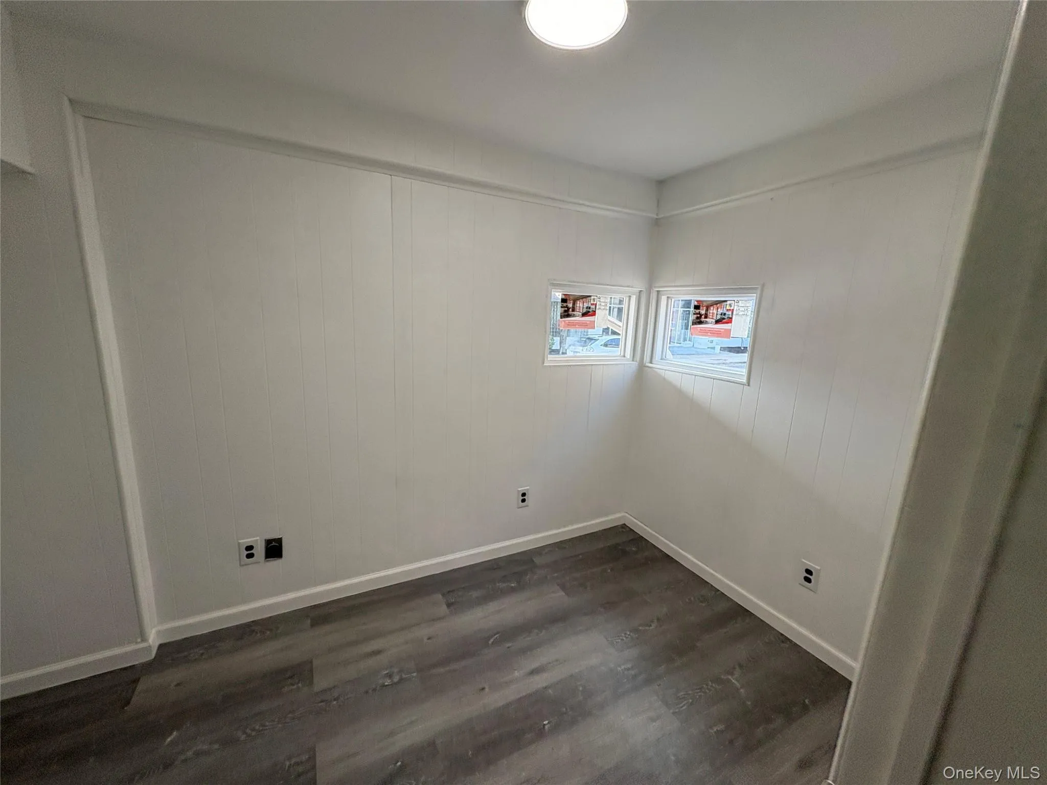 Laundry room with dark wood-type flooring and baseboards Laundry room with dark wood-type flooring and baseboards